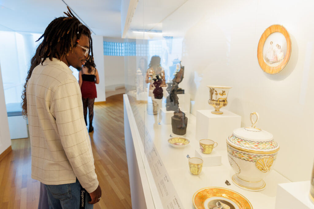 Man looks at a collection of porcelain objects