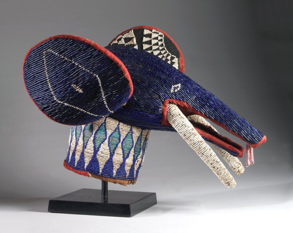 blue beaded elephant headdress with long white tusks and a diamond pattern on the ears and neck.