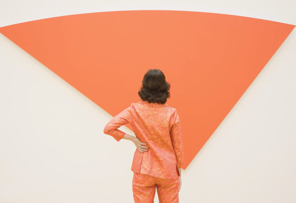 Women in all red outfit stands in front of Ellsworth Kelly's Red Curve VI
